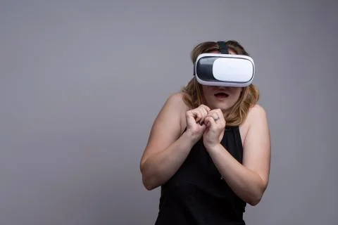 Young female using 3D VR gadget is displaying a terrified and shocked emotion Stock Photos