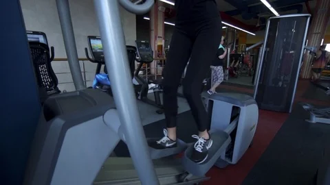 Young Female using Elliptical Cross Trainer in Gym Stock Footage 122567169