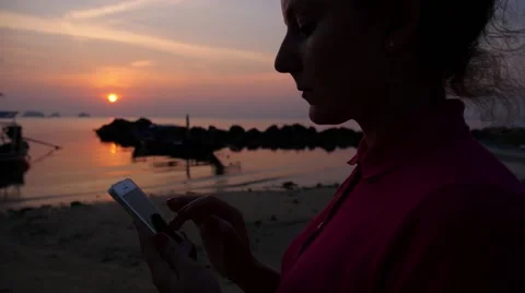 Young Female Using Mobile Phone on Tropical Beach at Sunset. Slow Motion Stock Footage 48048704