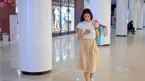Young female using navigation app on phone to find store in shopping mall Stock Footage 157129554