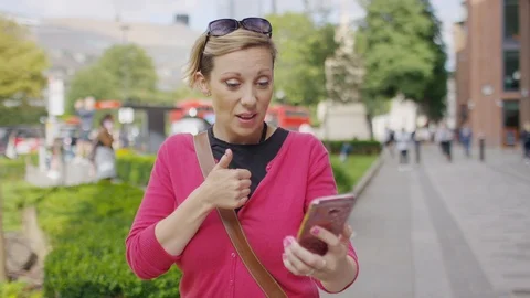 Young female using sign language on a video call as she walks in the city Vidéo 114023733