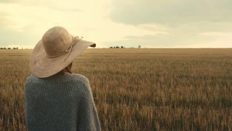 Young female walking through anempty field on a warm day. Stock Footage 134645916