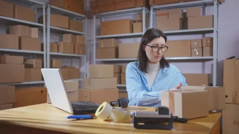 A young female warehouse worker uses a barcode scanner in her work Video stock 272909618