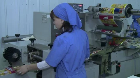 A young female worker controls pre-packaged fast food noodle briquettes Stock Footage 149072639