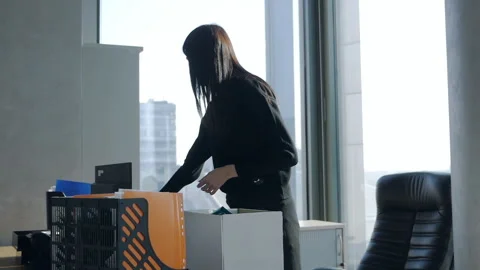 Young female worker stands at the table in the office room. Packing his work Vídeo Stock 154658928