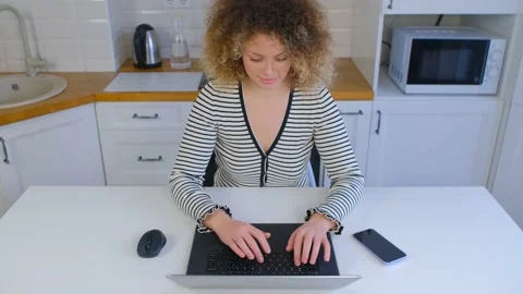 Young female working on laptop computer in kitchen  Stock Footage 217381231