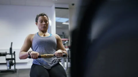 Young female working out on a rowing machine at the gym, in slow motion Stock Footage 59745514