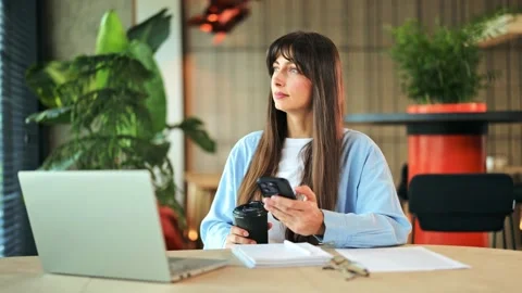 Young Female Working Remotely, Checking Phone Enjoying Coffee in Modern Cafe 스톡 동영상 313034050