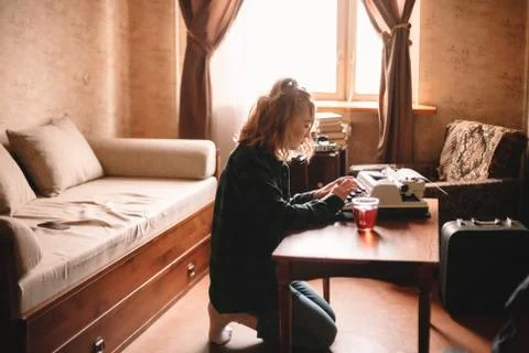 Young female writer using typewriter at home Stock Photos