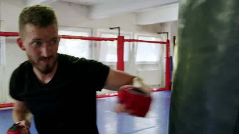 Young fighter practicing punching on a punching bag 4K. Stock Footage 234614883