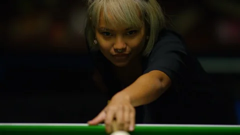 Young Filipino female concentrating on her shot in a game of billiards or pool Stock Footage