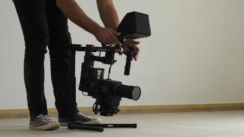 Young filmmaker preparing high tech camera on stabilizer for shooting Stock Footage 88698708