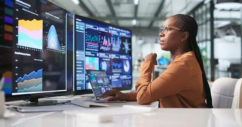Young Financial Analyst Using Laptop To Review Real-time Dashboard Data. Stock Photos