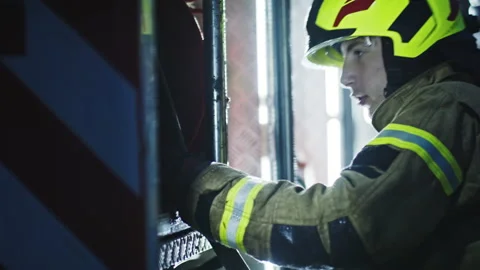 Young firefighter checking the hose on the fire engine Stock Footage 140643540