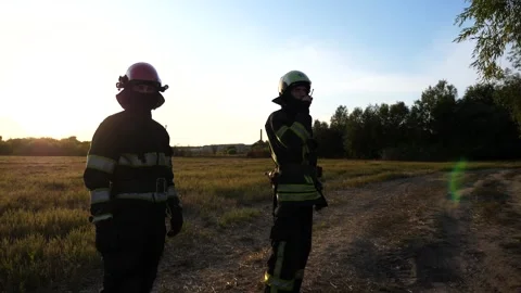 Young fireman in full equipment talking on walkie-talkie at countryside. Male Vídeos de archivo 347873358