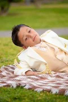 Young First Communion boy lying on a blanket outdoors Stock Photos