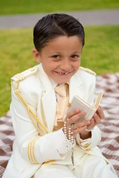 Young First Communion boy smiling with prayer book and rosary Stock Photos
