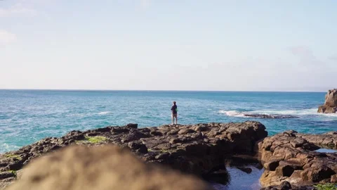 A young fisherman at the end of a rock, casting his lure Vídeos de archivo 345888460