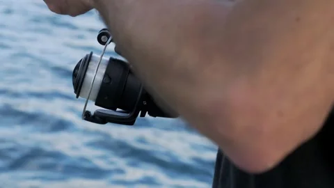 Young fisherman hands using spinning reel during peaceful outdoor fishing trip Stock-Footage 335701837