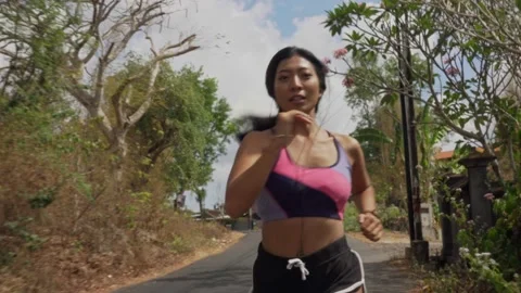 Young fit and active runner exotic woman running and jogging at countryside road Stock Footage 131803392