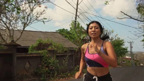 Young fit and active runner exotic woman running and jogging at countryside road Stock Footage 131803481