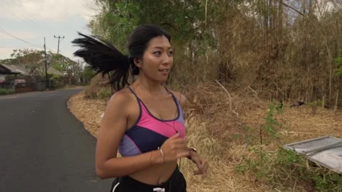 Young fit and active runner exotic woman running and jogging at countryside road Stock Footage 131803487
