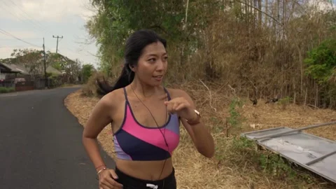 Young fit and active runner woman running and jogging at countryside street Stock Footage 131803507