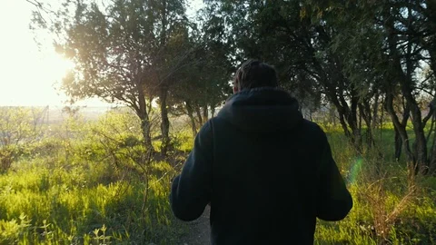 Young fit man in black jacket running in the beautiful park on sunset. Green 動画素材 106731322