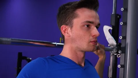 A young fit man does overhead presses in a gym - face closeup from the side Stock-Footage 85878478