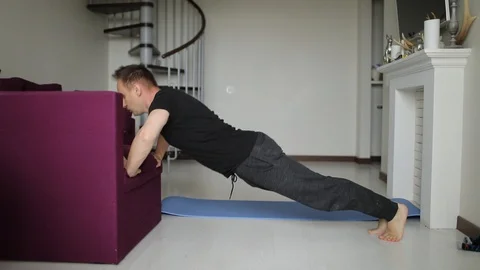 A young fit man does push-ups in his living room at home. Sport and healthy Stock-Footage 130015369