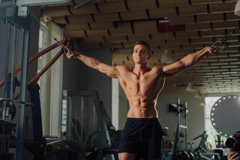 Young fit man doing maching chest exercises in the gym Stock Photos