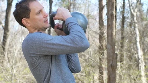 Young fit man exercising with heavy kettlebell weight lifting in slow motion Stock Footage 107937643