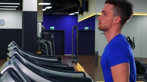 A young fit man jogs on a treadmill in a gym - closeup from side Stock Footage 85301881