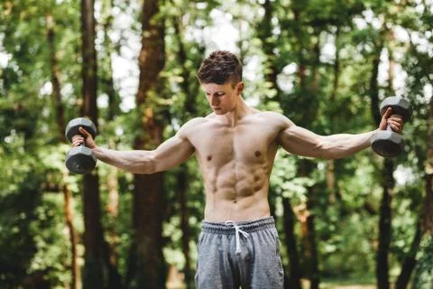 Young fit man lifting weights Stock Photos