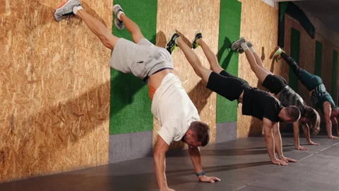 Young fit men doing handstand exercise in studio. Group of athletes gymnastic Stock-Footage 164685248