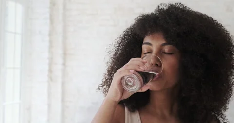 Young fitness athlete black woman drinking water after sport workout at home Stock Footage