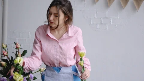 A Young Florist picks flowers eustoma and inspects them for her arrangement Stock Footage 86535170
