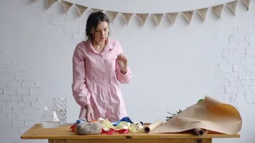 A young florist prepares a workstation to create a bouquet Stock Footage 85929355