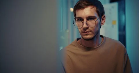Young Focused Developer Looking at Computer Screen in Dark Tech Office. Video stock 306739637