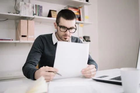 Young focused employee working with documents in office Stock Photos
