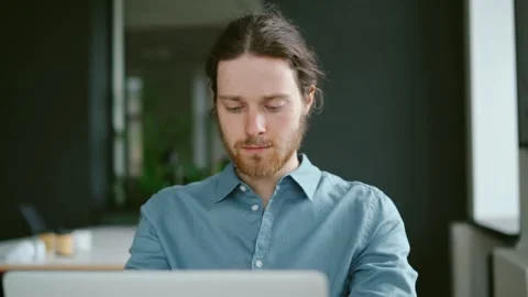 Young focused man freelancer working on laptop computer remotely Stock Footage 155792802