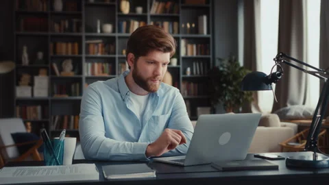 Young focused man working at laptop computer Stock Footage 260925729
