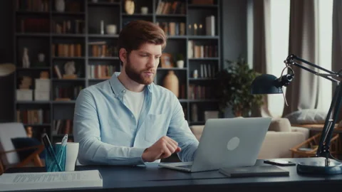 Young focused man working at laptop computer Stock Footage 260926576