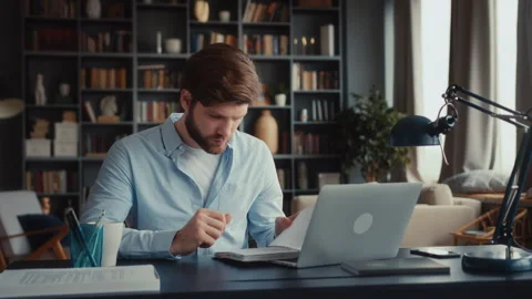 Young focused man working at laptop computer Stock Footage 260927498