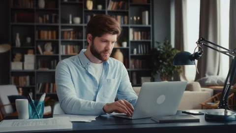 Young focused man working at laptop computer Stock Footage 260928834