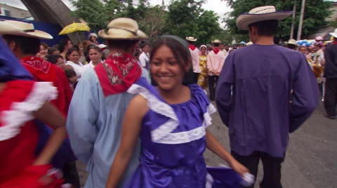Young folk dancers parading through street in San Salvador, accompanied by band Stock Footage 59535887