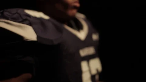 Young football player puts his pads and uniform on Stock Footage
