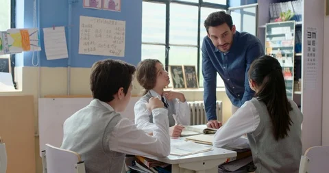 Young foreign teacher helping students in class,4K Stock Footage 120898652