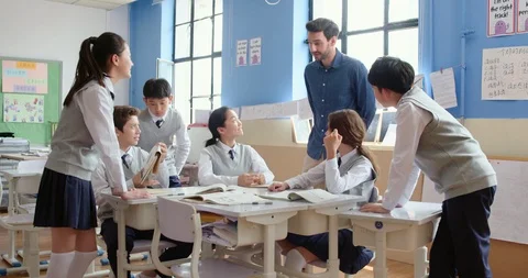 Young foreign teacher helping students in class,4K Stock Footage 120904460
