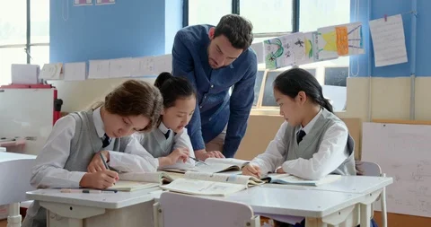 Young foreign teacher helping students in class,4K Stock Footage 120907741